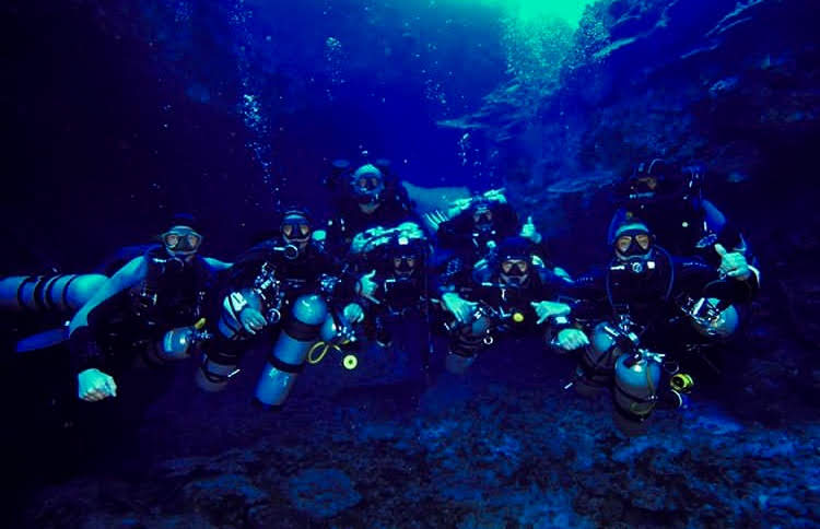 Buzo técnico con twinset y stage realizando parada de descompresión con SMB desplegada.